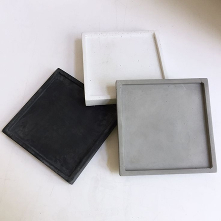 Three square trays in black, white, and grey